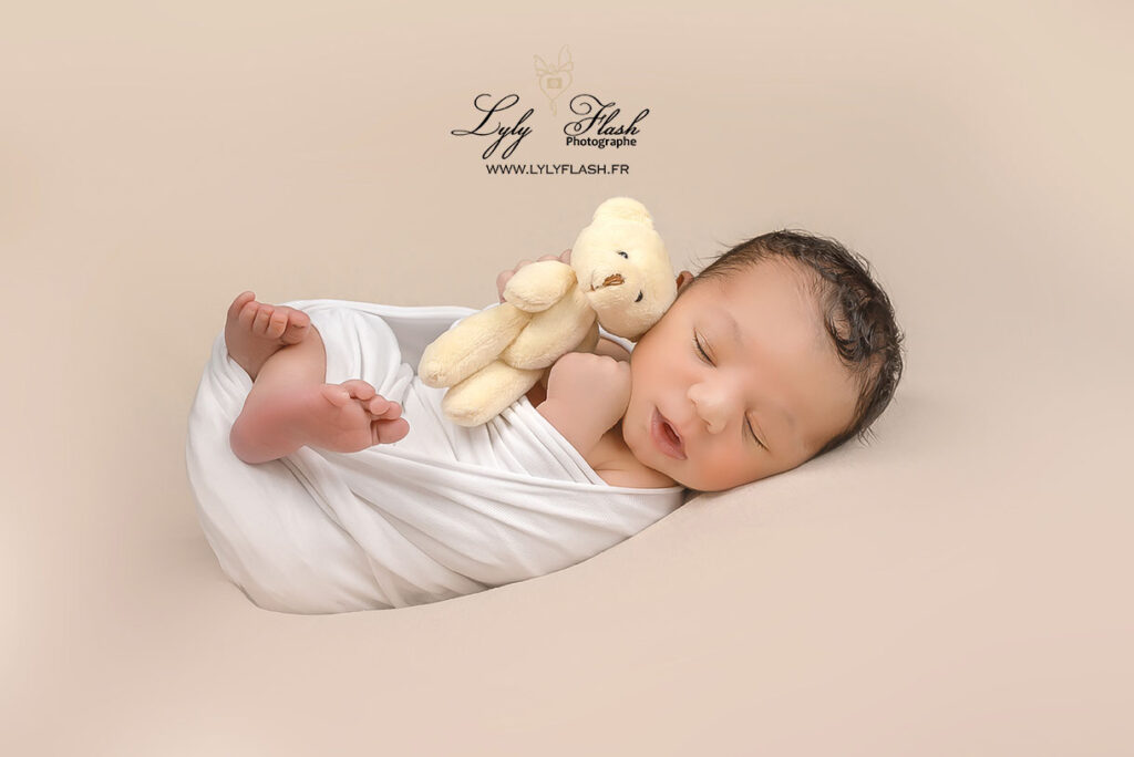 photo bébé métisse qui dort avec son doudou en shooting photo