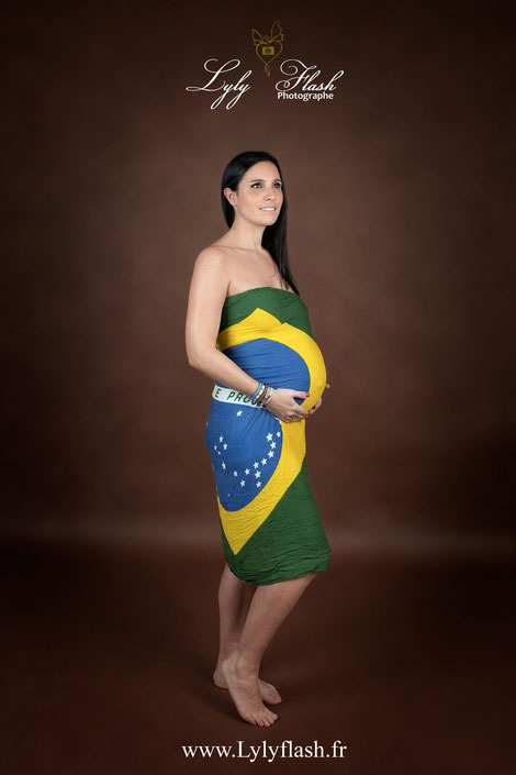 photo d une femme enceinte portant le drapeau du Brésil pour mettre ses racines en valeur. Une photo qui deviendra un pilier des souvenirs de la vie de bébé a naître