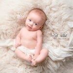 a baby lying on a blanket