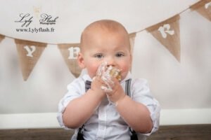 un bébé mange son gâteau et en a plein le visage