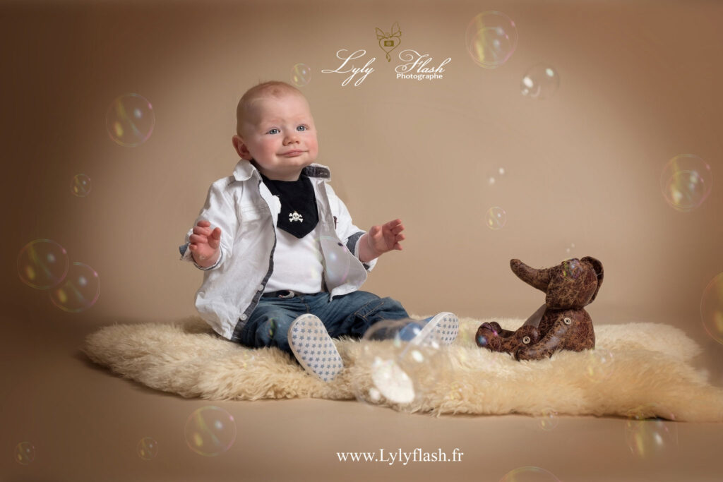 photo d un bébé de 9 mois qui rigole devant des bulles en shooting photo