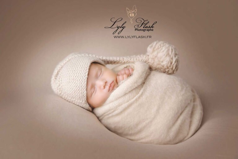 Bébé emmailloté dans un wrap beige lors d’une séance photo naissance à Brignoles