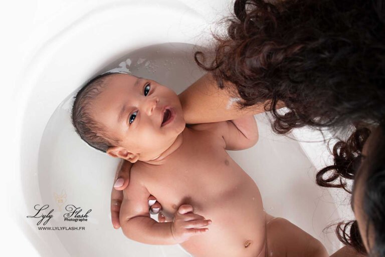photo d un bébé qui prend son bain et qui fait un sourire a sa maman