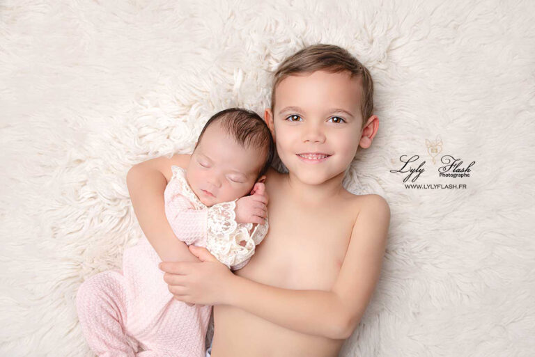 photo d un grand frère de 6 ans avec sa petite sœur de 8 jours au studio photo lyly flash de Brignoles