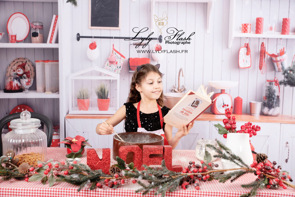 photo de Noël dans la cuisine une enfant prépare un gâteau