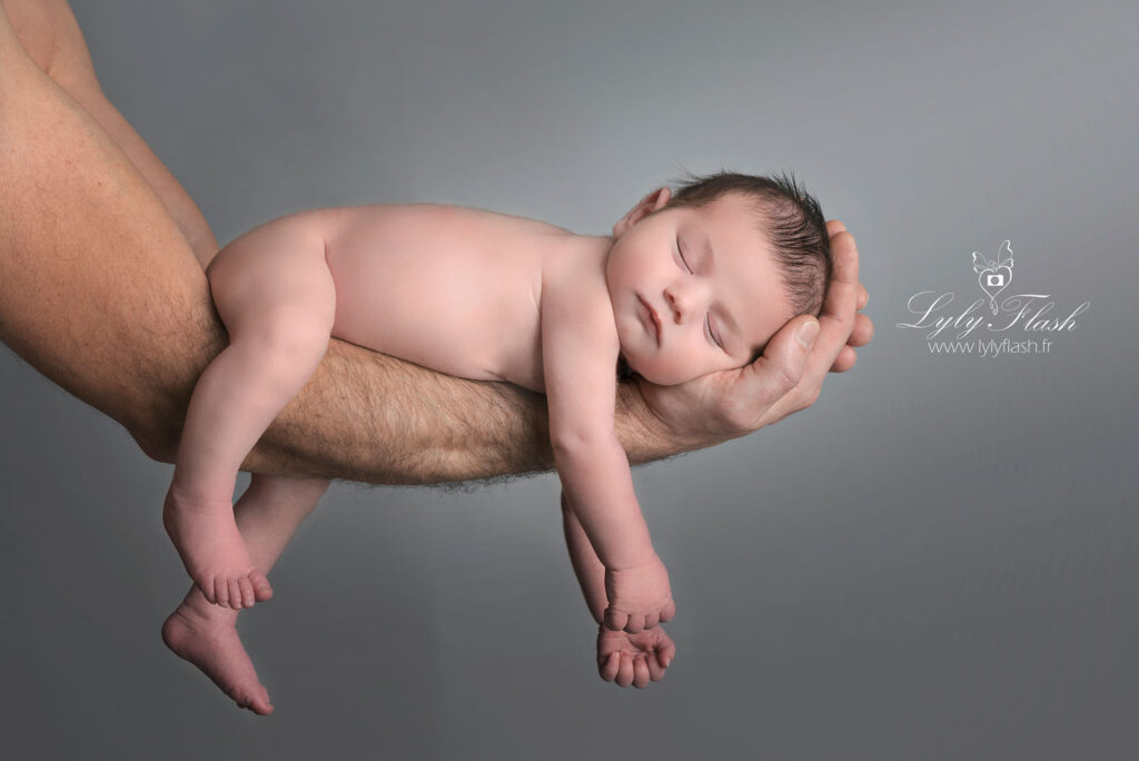 bébé qui dort en sécurité sur le bras de ses parents