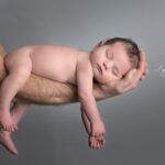 bébé qui dort en sécurité sur le bras de ses parents