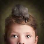 photo d un enfant avec un poussin sur la tête