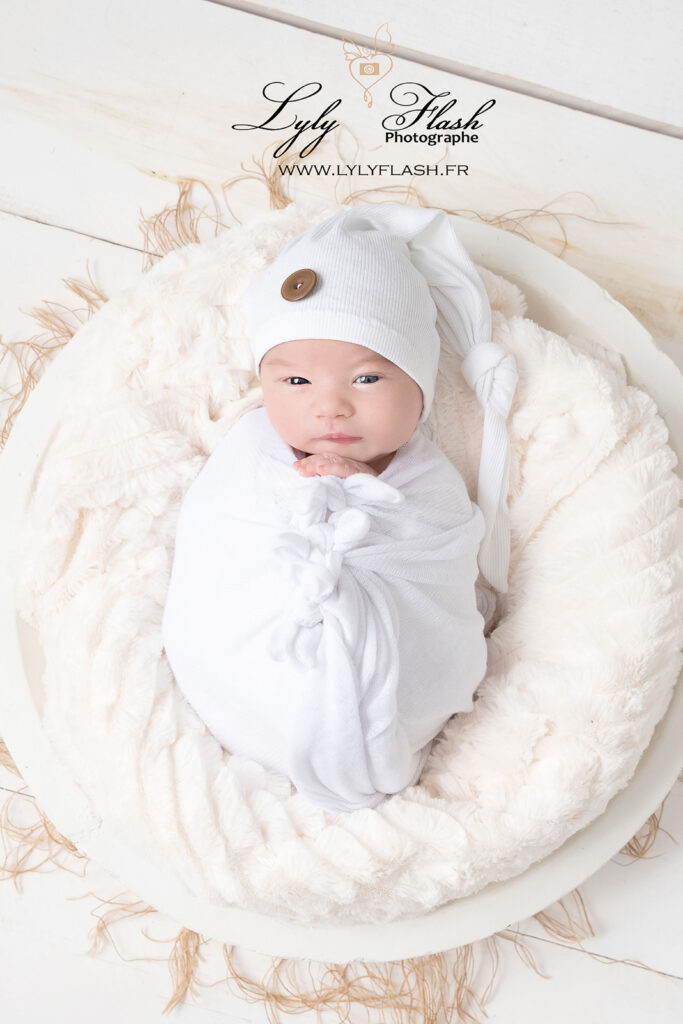 L'emmaillotage sécurise le bébé pour une photo nouveau-né calme et détendue