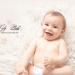 un bébé qui rigole sur une photographie studio