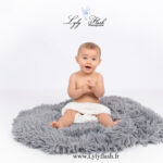 photo de bébé super heureux qui applaudit avec les main en shooting photo studio blanc et pure