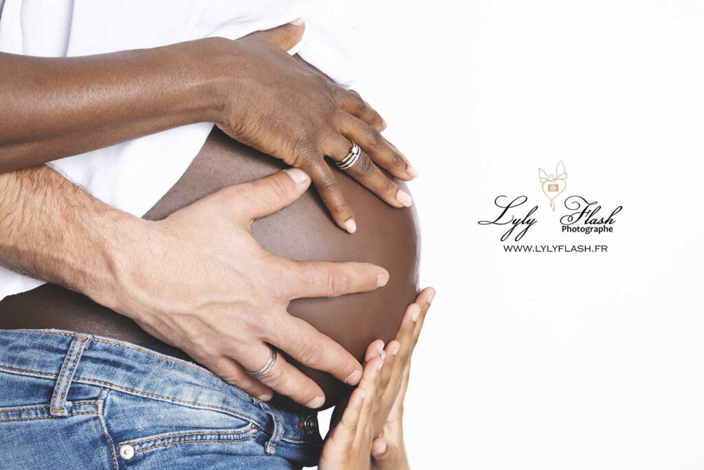 photographe grossesse studio les mains de la famille sont posées sur le ventr de la future maman