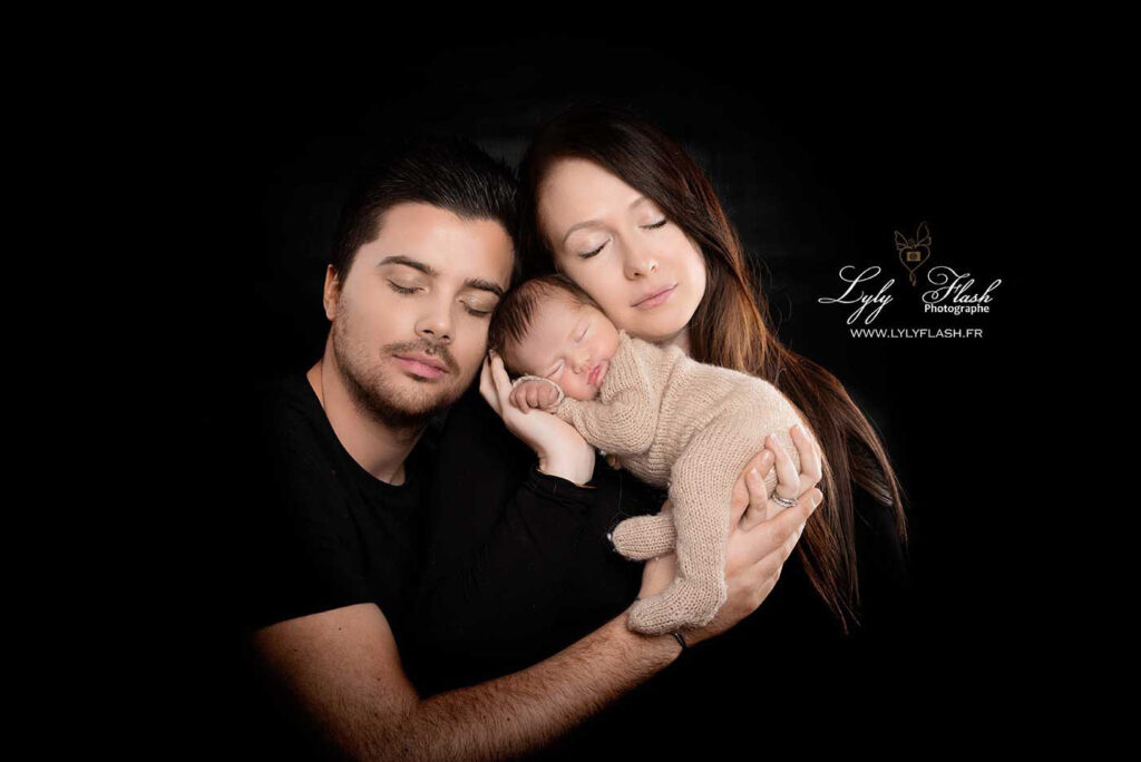 magnifique photo de famille sur fond noir avec un nouveau-né et ses parents