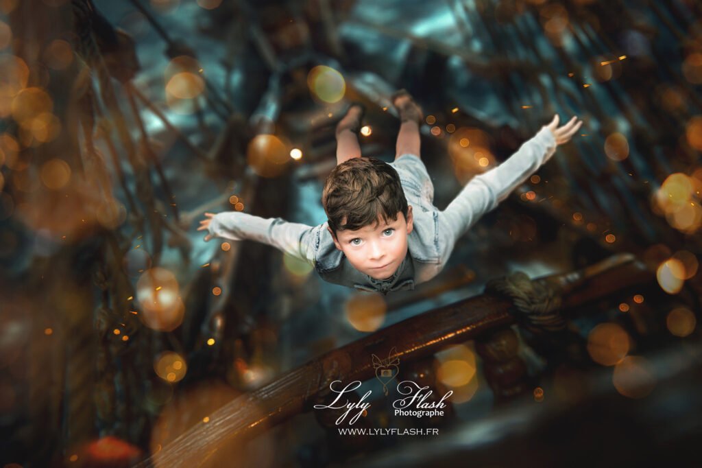 photo d enfant artistique sur le thème de Peter pan , un garçon vole le long d un bateau de pirate vers l objectif de la photographe Lyly flash Garéoult