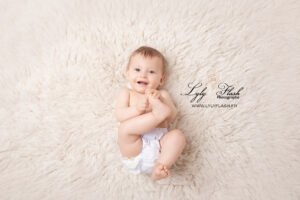 un bébé de 9 mois attrape son pieds sous l objectif de la photographe de l'enfance lyly flash a Brignoles