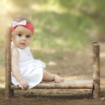 quand la photographe se sert de la douceur de la lumière pour sublimer une petite fille, bébé par le fait d être assise sur un petit lit en bois, un instant suspendu près de Collobrières