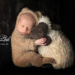 photo de naissance bébé et doudou qui se font un gros câlin, une photographie toute douce car le nouveau-né porte un déguisement de doudou