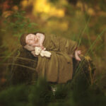 bébé dans la foret, une photographie issue d'un montage numérique pour permettre aux parents d'obtenir une photographie de naissance en pleine nature tout en garder la chaleur du studio confortable pour le nouveau-né