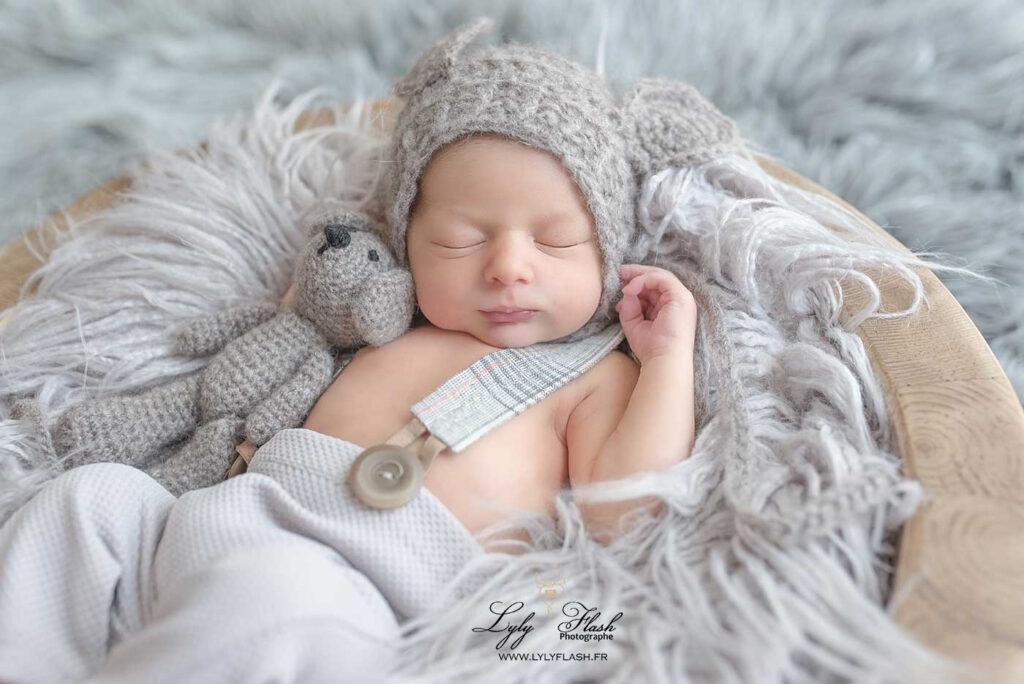 Un beau bébé de Briançon en séance photo naissance dans le studio photo de Lyly flash, une atmosphère douce et cosy, avec cette lumière diffuse, ce petit bonnet gris assorti au doudou qui met en valeur la pureté de ce petit garçon de quelques jours
