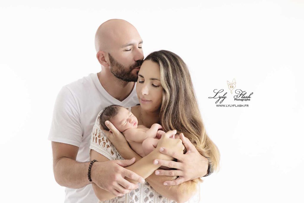 Un couple tient dans ses main un bébé tellement attendu, quand le bonheur se trouve dans le creux de vos mains, la séance photo cocoon naissance est faites pour vous