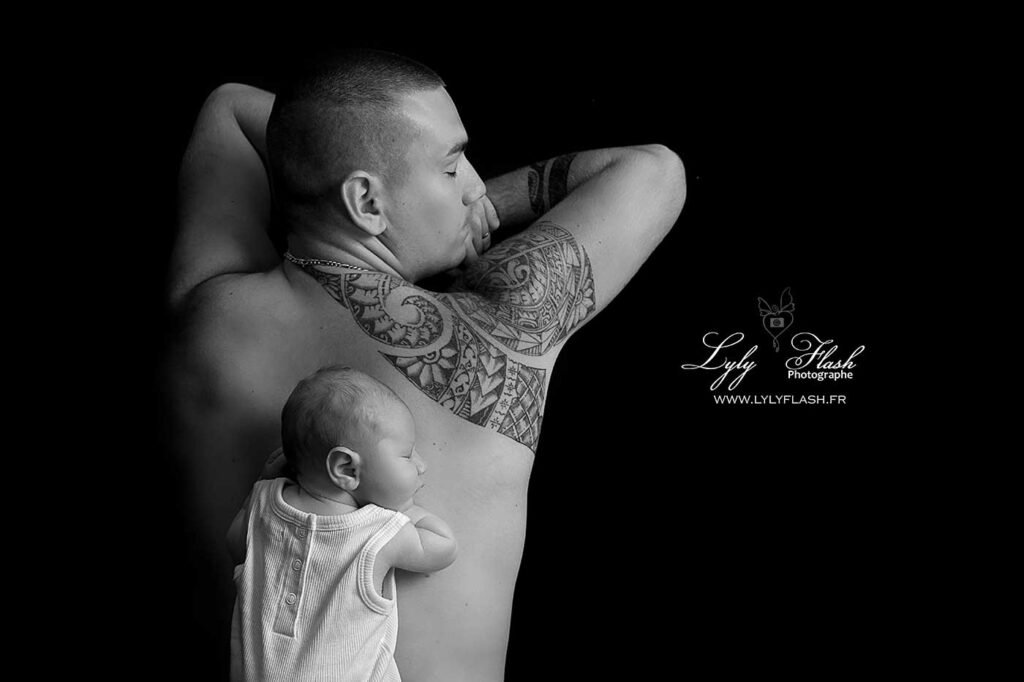 un bébé dort sur le dos de son papa qui fait la sieste pour mettre en valeur leur différence de taille et de fragilité, photographie en noir et blanc réalisée par la photographe spécialiste de la photo de famille Lyly Flash