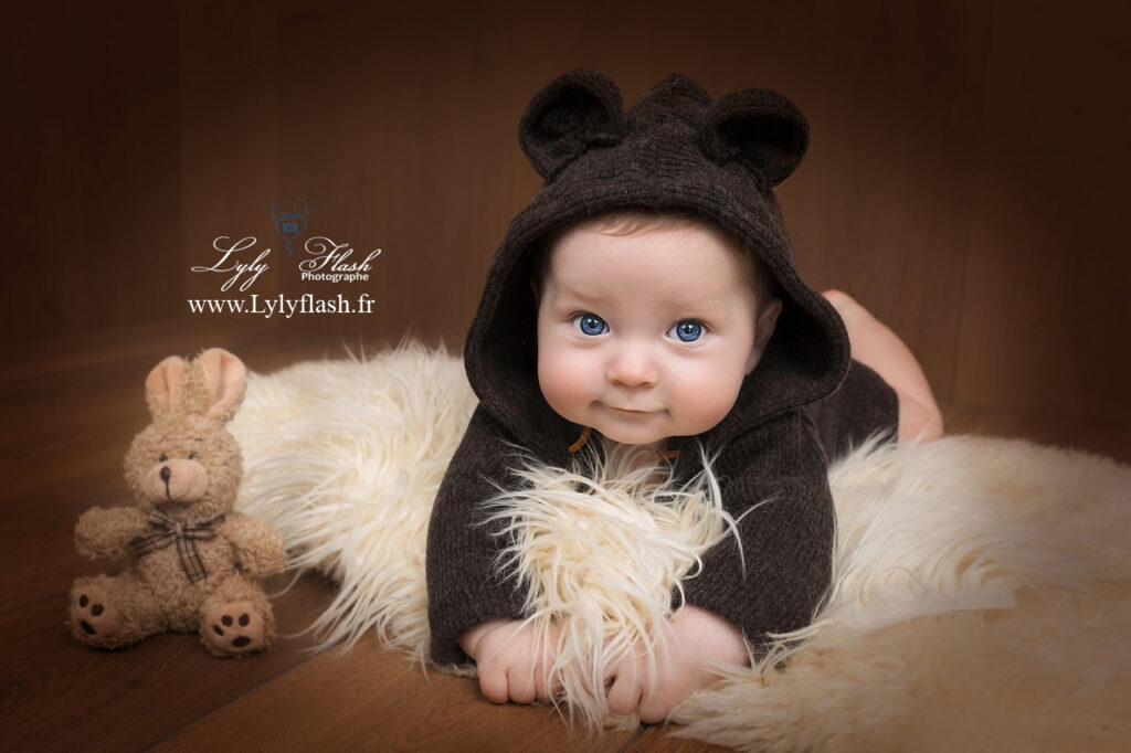 photo bébé sur le  vntre avec un bonnet ourson dans un studio du var