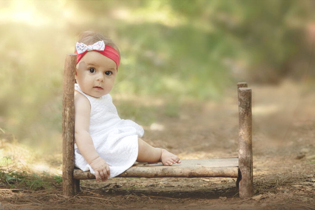 photographie d une petite puce de 9 mois dans un lit en bois dans les jardin de Brignoles