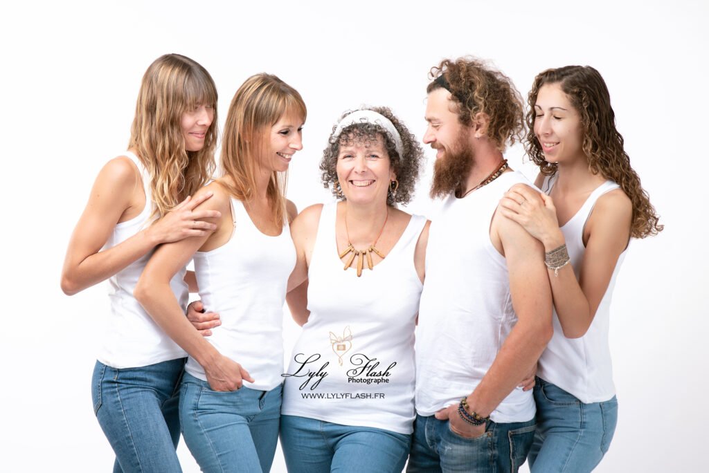 Devant un fond clair, la famille est debout, disposée en rangées. La grand-mère, élégante, se trouve au centre, encadrée par ses trois filles à sa droite et à sa gauche, tandis que son fils est légèrement en retrait, souriant avec fierté. La petite fille est assise sur un tabouret devant eux, ajoutant une note d'innocence.