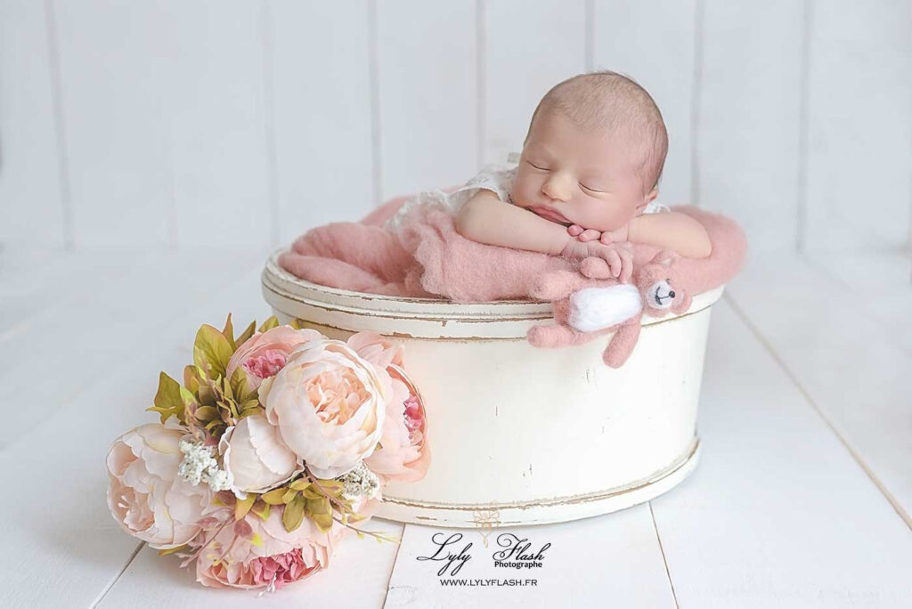 1 Une belle petite fille de 5 jours encore nourrisson dors dans un contenant en bois pour une photographie raffine et douce réalisée pour une famille d'Antibes par la photographe Lyly Flash
