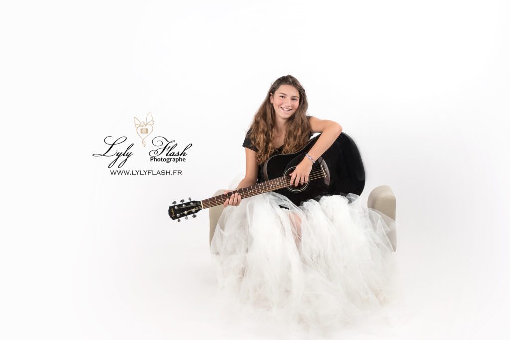 une adolescente joue de sa guitare en séance photo