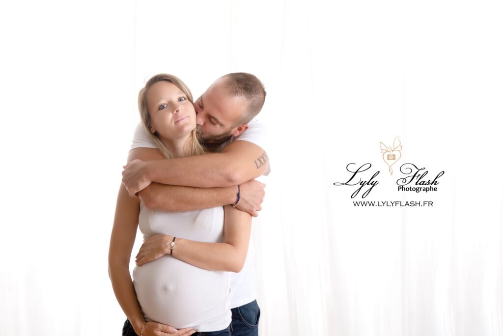 un couple amoureux devant l objectif le papa fait un bisous a la future maman