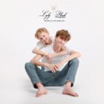 Famille souriante avec leur adolescent durant une séance photo complice au studio