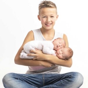 photo du grand frère qui porte les jumelles a la naissance