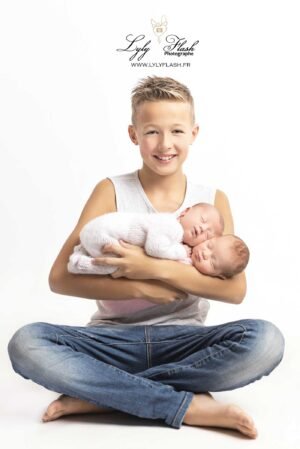 photo du grand frère qui porte les jumelles a la naissance
