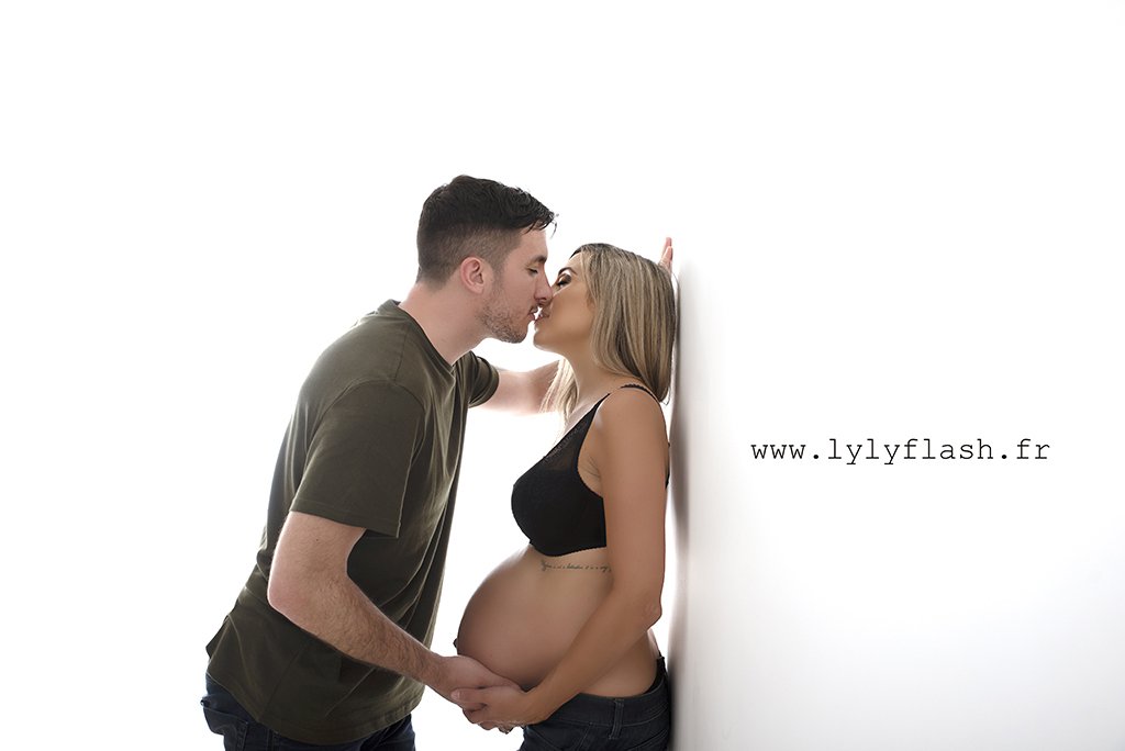 un couple s'embrasse la femme enceinte est dos sure le mur