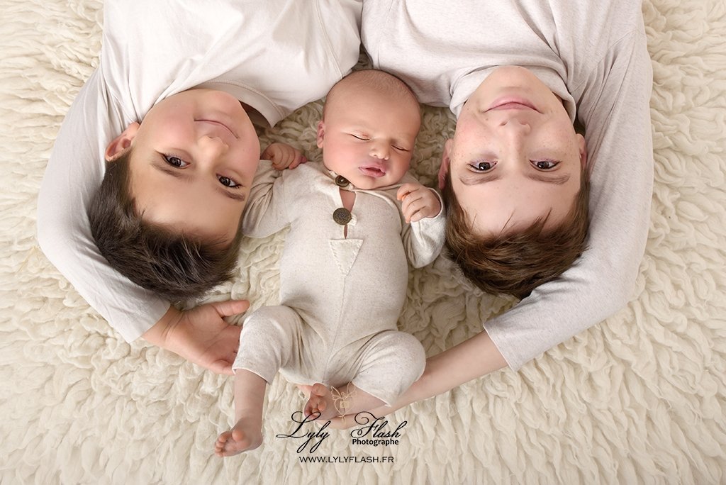 deux frères protègent leur nouveau-né lors d 'une pose cocoon de naissance